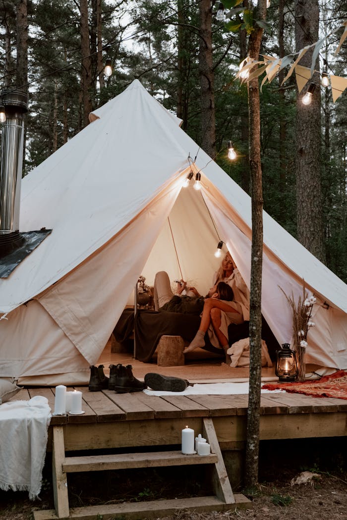 A romantic and cozy glamping scene in a luxurious forest tent with warm lighting.